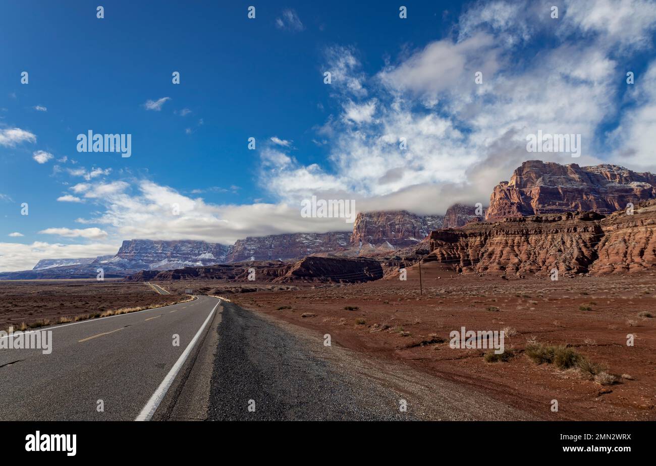 Autostrada 89a a Marble Canyon, Arizona, con le scogliere Vermilion coperte di neve sullo sfondo Foto Stock