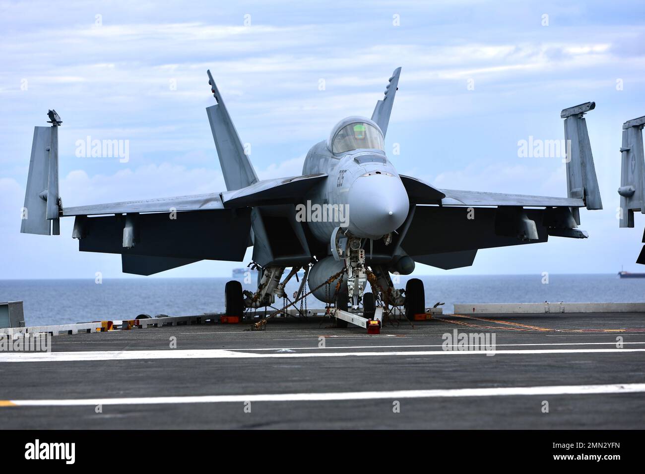 Un F/A-18 Hornet siede sul ponte della USS Ronald Reagan (CVN 76). Soldiers from B Company, 3-2 General Support Aviation Battalion, 2nd Combat Aviation Brigade condusse atterraggi con elicotteri CH-47F Chinook sull'unico portaerei della Marina statunitense, USS Ronald Reagan (CVN 76), nelle acque ad est della penisola coreana il 26 settembre 2022. Le qualifiche di atterraggio sul ponte sono condotte per certificare i membri dell'equipaggio e i piloti che atterrano su una nave. Questo corso di formazione è stato condotto in parte con l'esercizio di operazioni speciali per il banco marittimo (MCSOFEX) per rafforzare l'inter Foto Stock