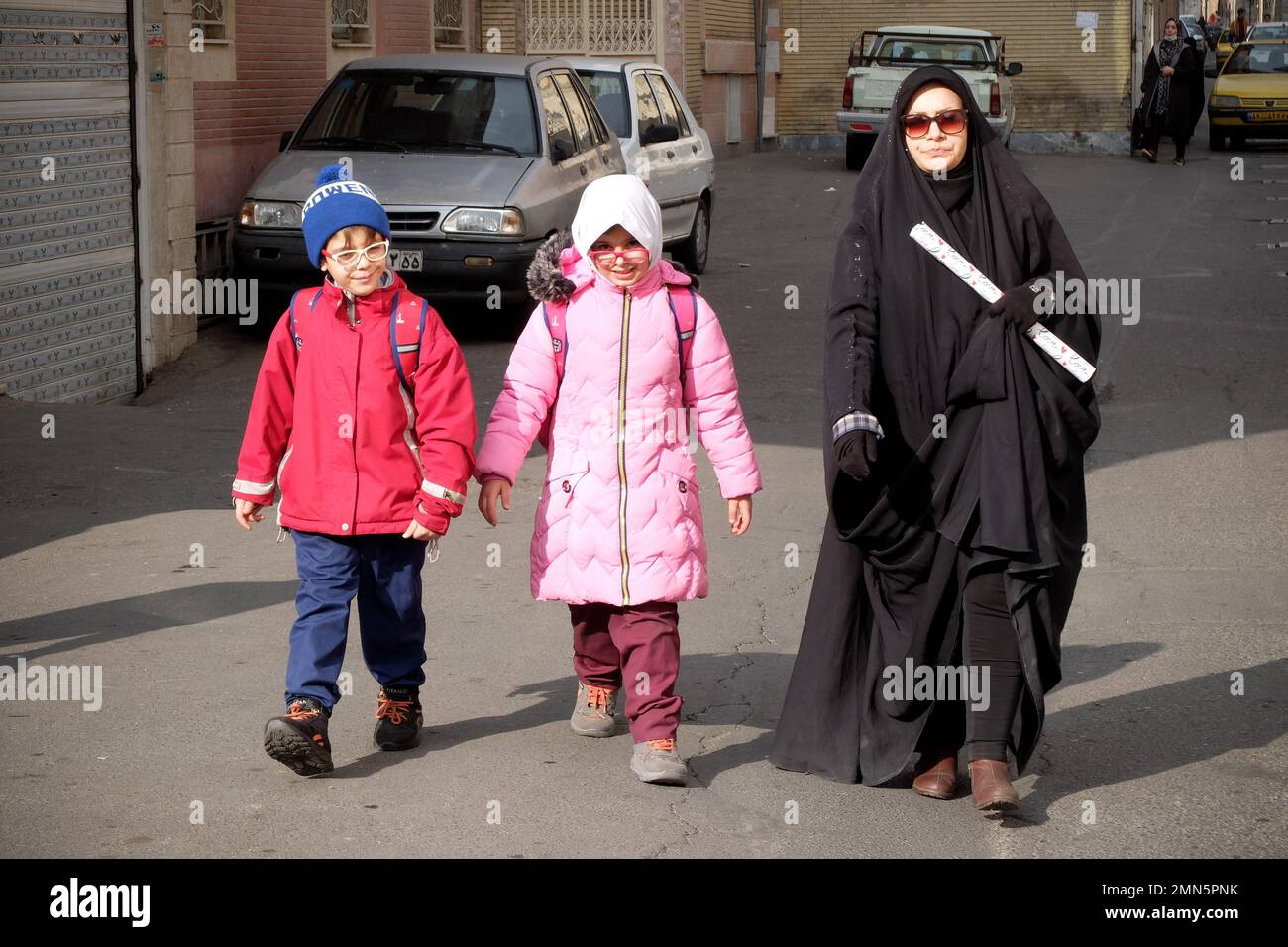 Teheran, Teheran, Iran. 29th Jan, 2023. Una donna velata iraniana con i suoi bambini-scuola cammina nel distretto di Shapour, nel sud di Teheran, in Iran, il 29 gennaio 2023. Dalla metà di settembre, l'Iran è scosso dalle proteste antigovernative che sono state accese dalla morte di una donna detenuta dalla polizia morale del paese. Le manifestazioni si sono rapidamente aggravate in inviti a porre fine a più di quarant'anni di governo clericale del paese. (Credit Image: © Rouzbeh Fouladi/ZUMA Press Wire) SOLO PER USO EDITORIALE! Non per USO commerciale! Foto Stock