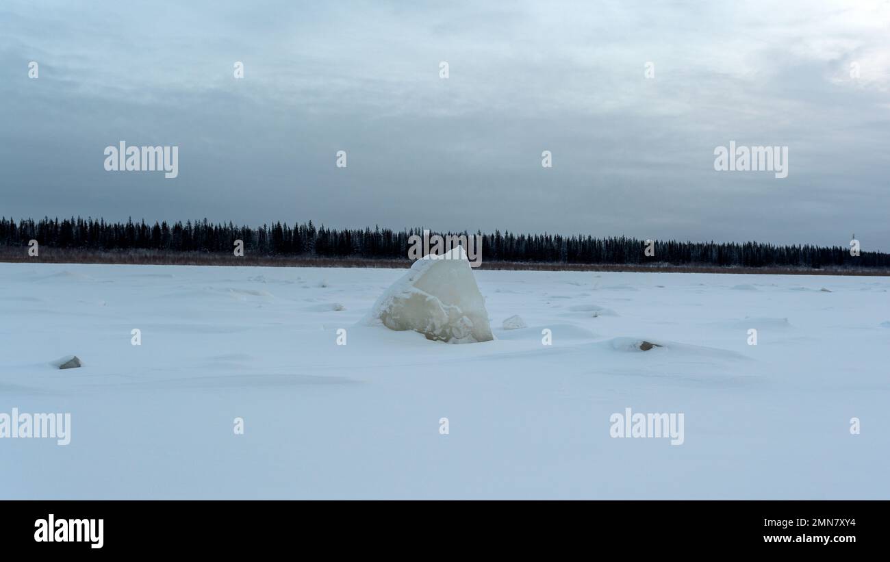 Un pezzo triangolare di ghiaccio che assomiglia a rocce si stacca dalla  neve sul fiume Vilyui a Yakutia in inverno sullo sfondo di una foresta con  potere Foto stock - Alamy