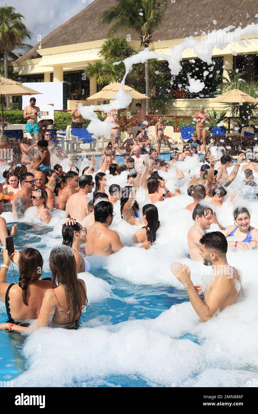 Gli ospiti che si divertono a una festa di Capodanno in schiuma in piscina in un hotel vicino ad Akumal, Quintana Roo, Riviera Maya, Messico Foto Stock