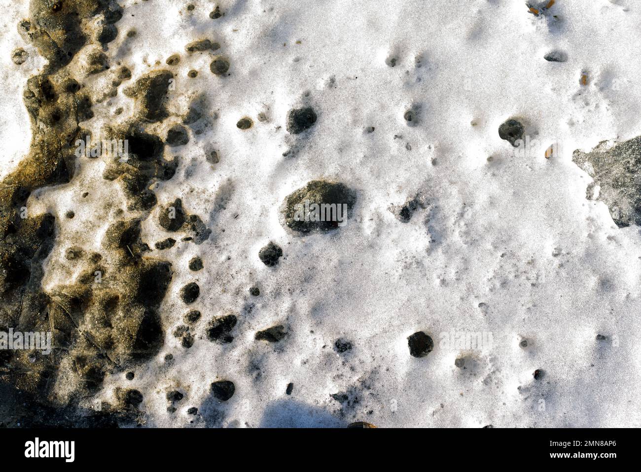 Struttura a terra con terra e neve alla luce del sole. Foto Stock