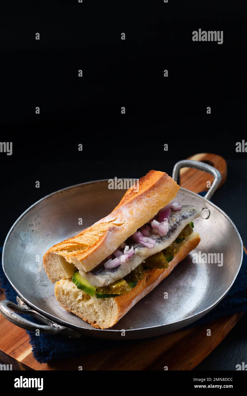 Sandwich di aringhe di concetto alimentare su sfondo nero con spazio copia Foto Stock