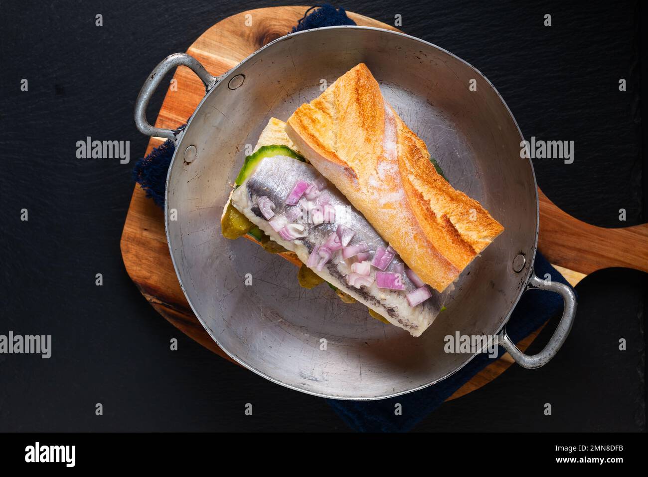 Sandwich di aringhe di concetto alimentare su sfondo nero con spazio copia Foto Stock