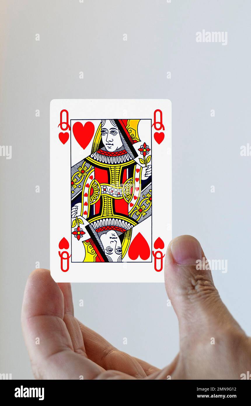 Mano con la carta da gioco della regina dei cuori Foto Stock