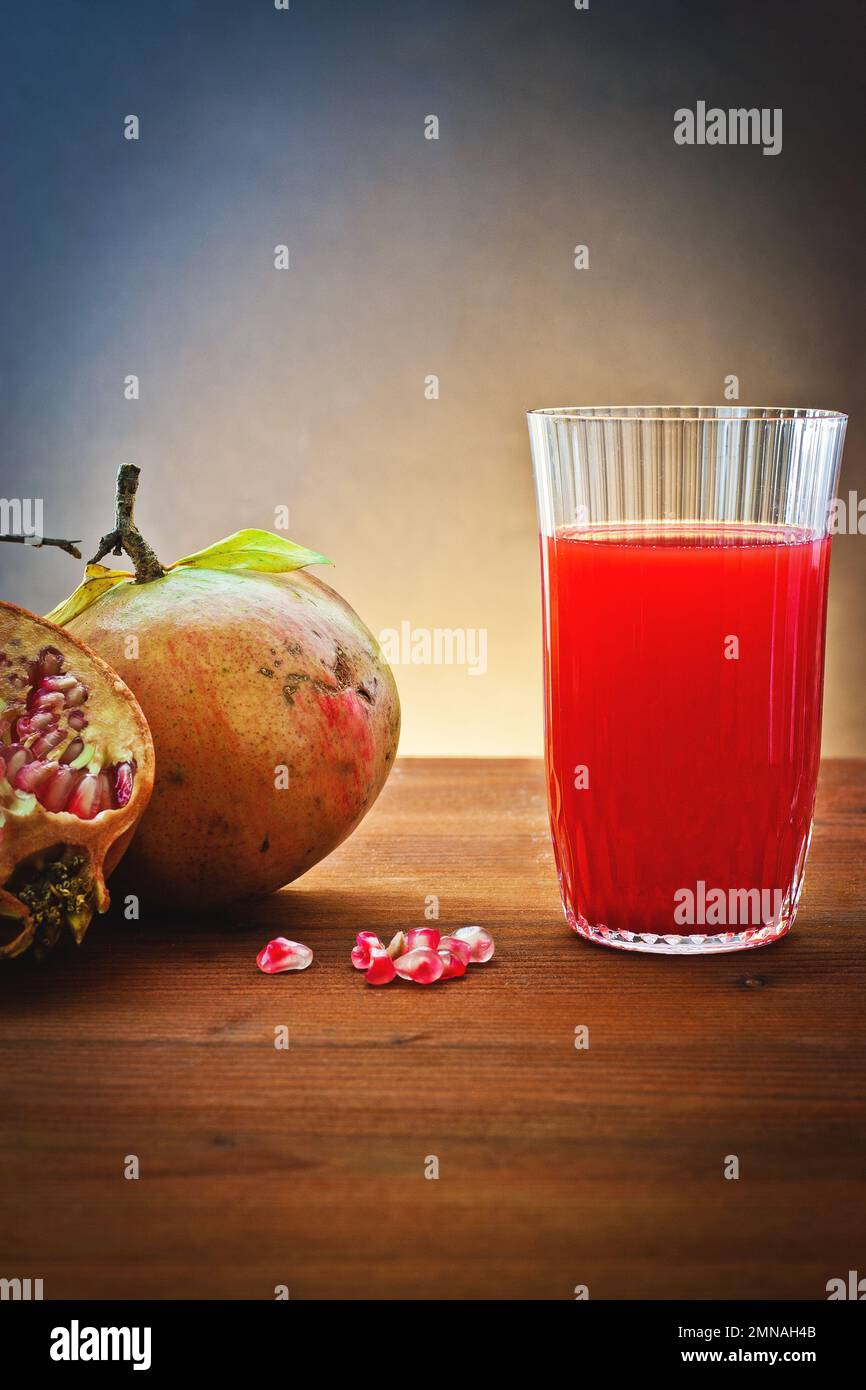 Melograno fresco con succo in bicchiere di vetro Foto Stock