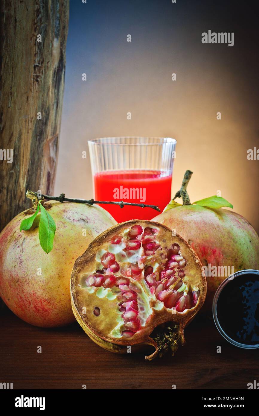 Melograno fresco con succo in bicchiere di vetro Foto Stock