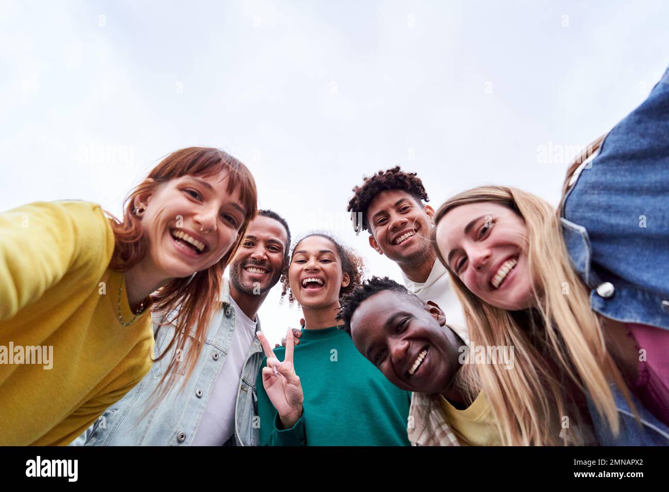 Copia l'immagine spaziale di un gruppo multiculturale di amici che prendono un selfie, guardando la macchina fotografica allegramente. Foto Stock