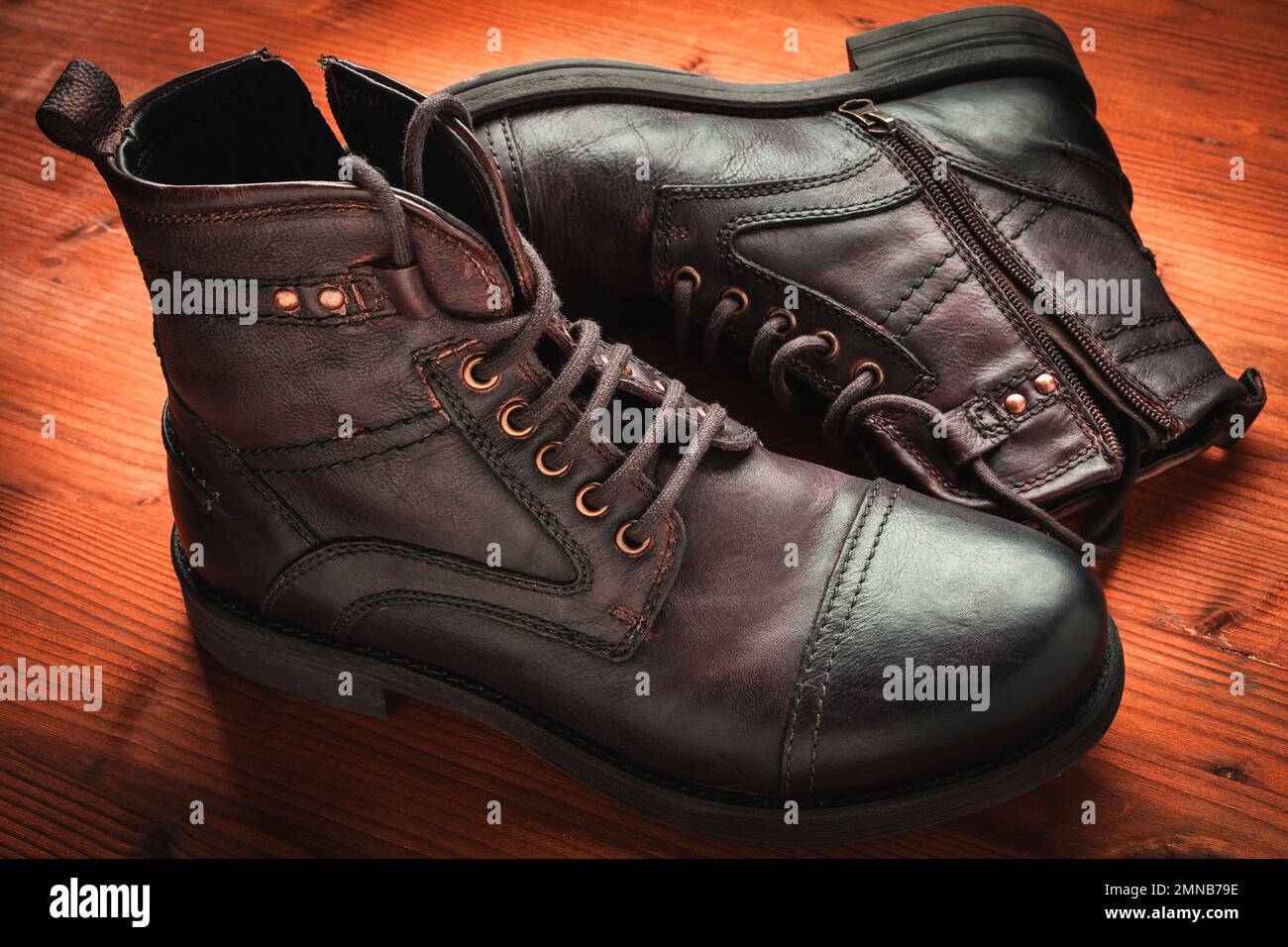 Stivali da uomo vintage in pelle marrone scuro su legno Foto Stock