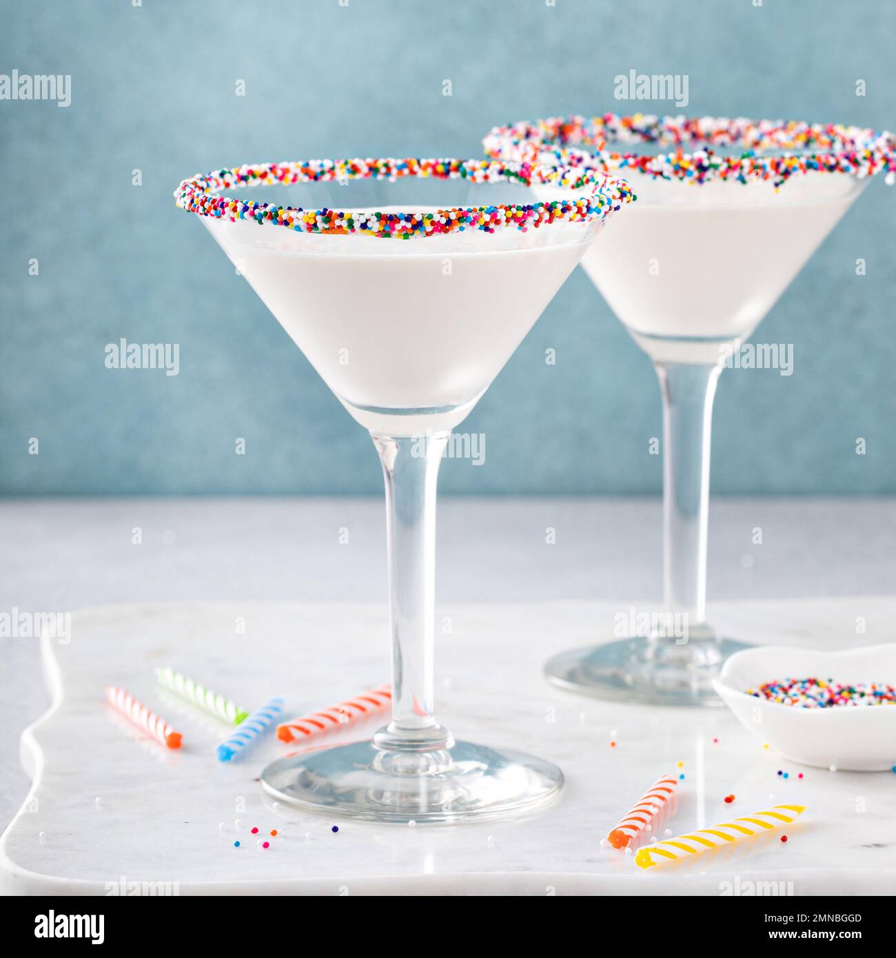Torta di compleanno martini con spolverini sul bordo di vetro e candele di compleanno Foto Stock
