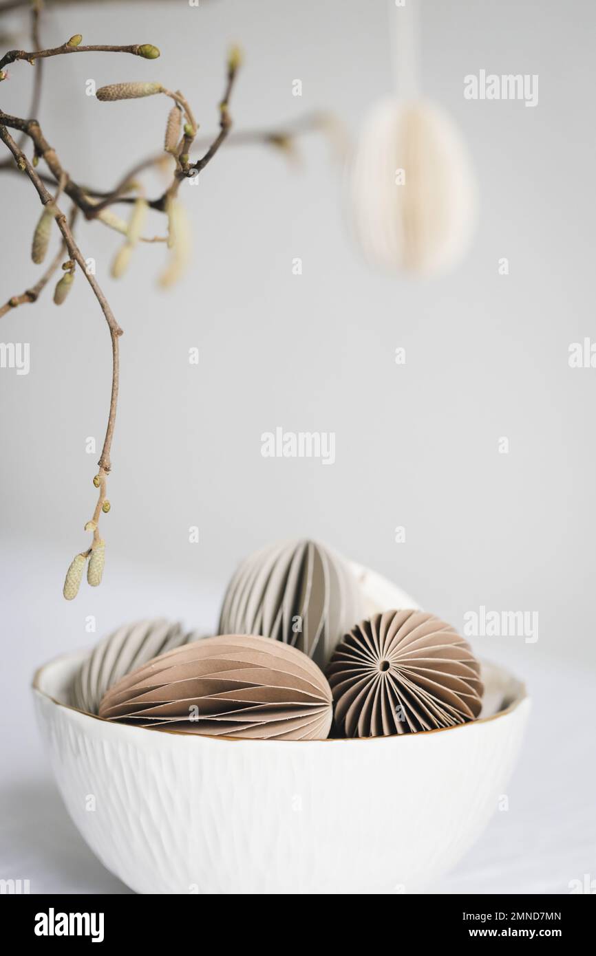 Decorazioni color pastello a forma di uovo di Pasqua, realizzate in cartone in ciotola bianca. Foto Stock