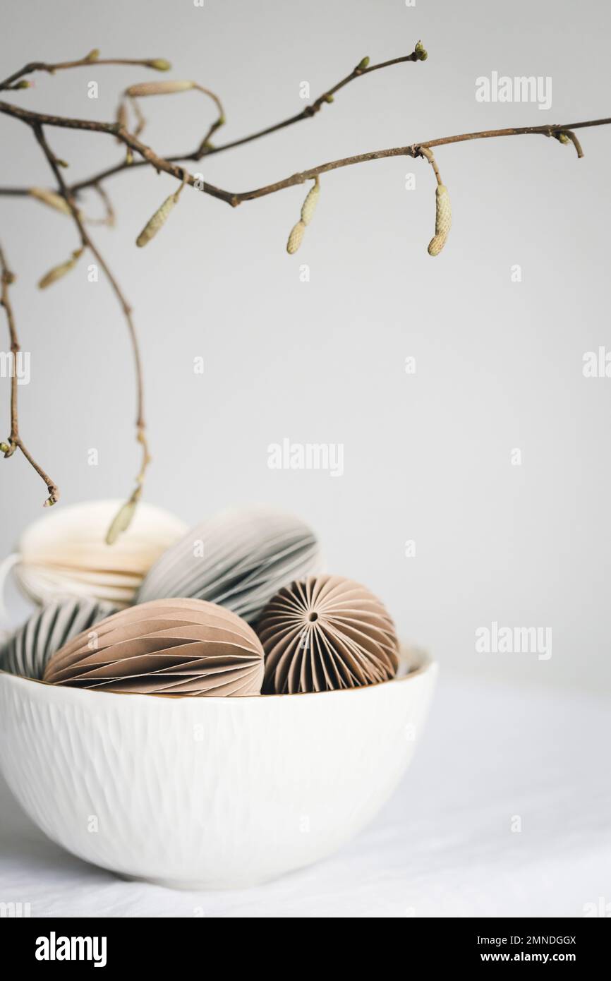 Decorazioni color pastello a forma di uovo di Pasqua, realizzate in cartone in ciotola bianca. Foto Stock