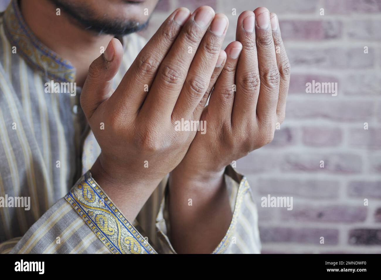 Uomo musulmano tenere la mano in gesti di preghiera durante ramadan, primo piano Foto Stock