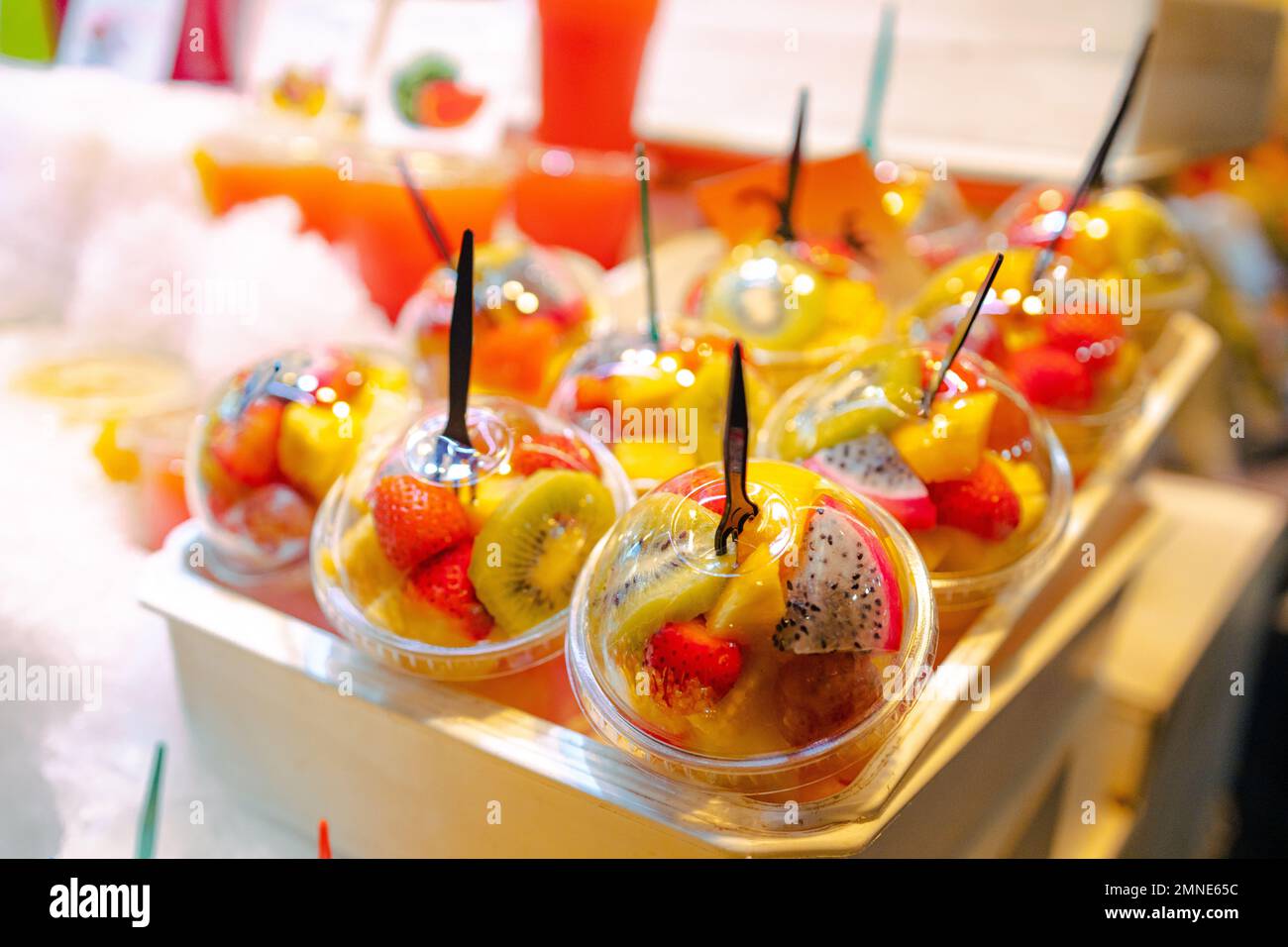 Insalata di cocktail di frutta fresca in tazze di plastica in una bancarella del mercato nel giorno estivo Foto Stock