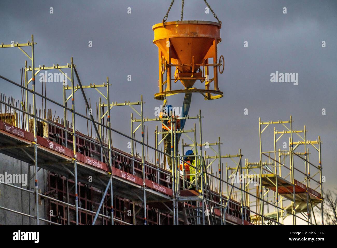 Lavori di calcestruzzo, al crepuscolo, in un grande cantiere di costruzione di un complesso residenziale e commerciale, NRW, Germania, Foto Stock