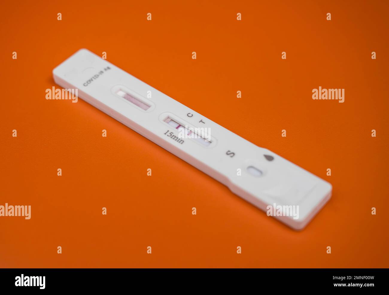 Cassetta per analisi, kit per analisi dell'antigene Covid-19, risultato positivo del test, autotest, Sars-COV-2, Corona virus, pandemia, esentato, sfondo arancione Foto Stock