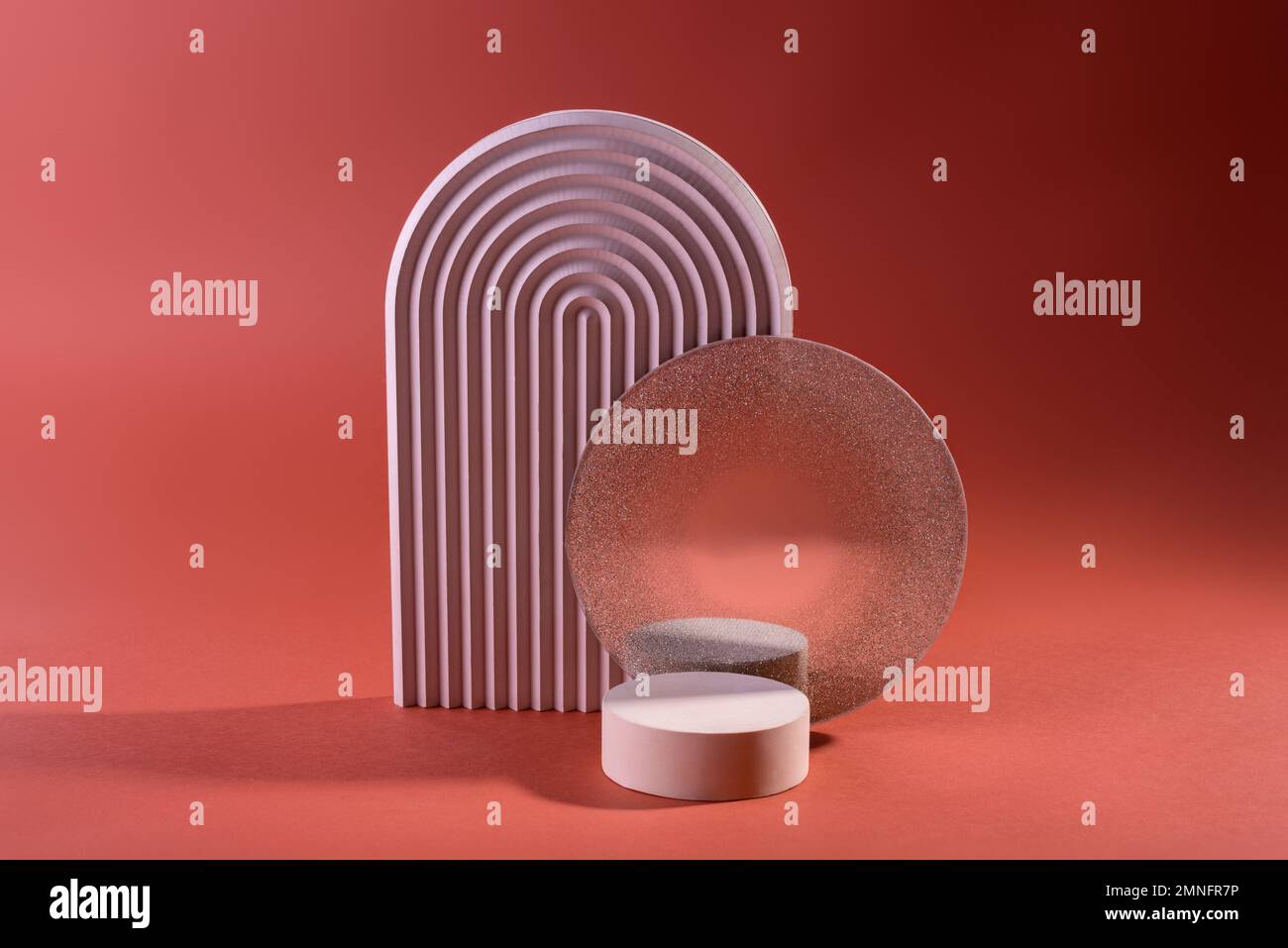 Composizione di podi geometrici o di colonnine di colore rosa sporco contro il rosso. Sfondo minimo per la visualizzazione della presentazione del prodotto cosmetico. Foto Stock