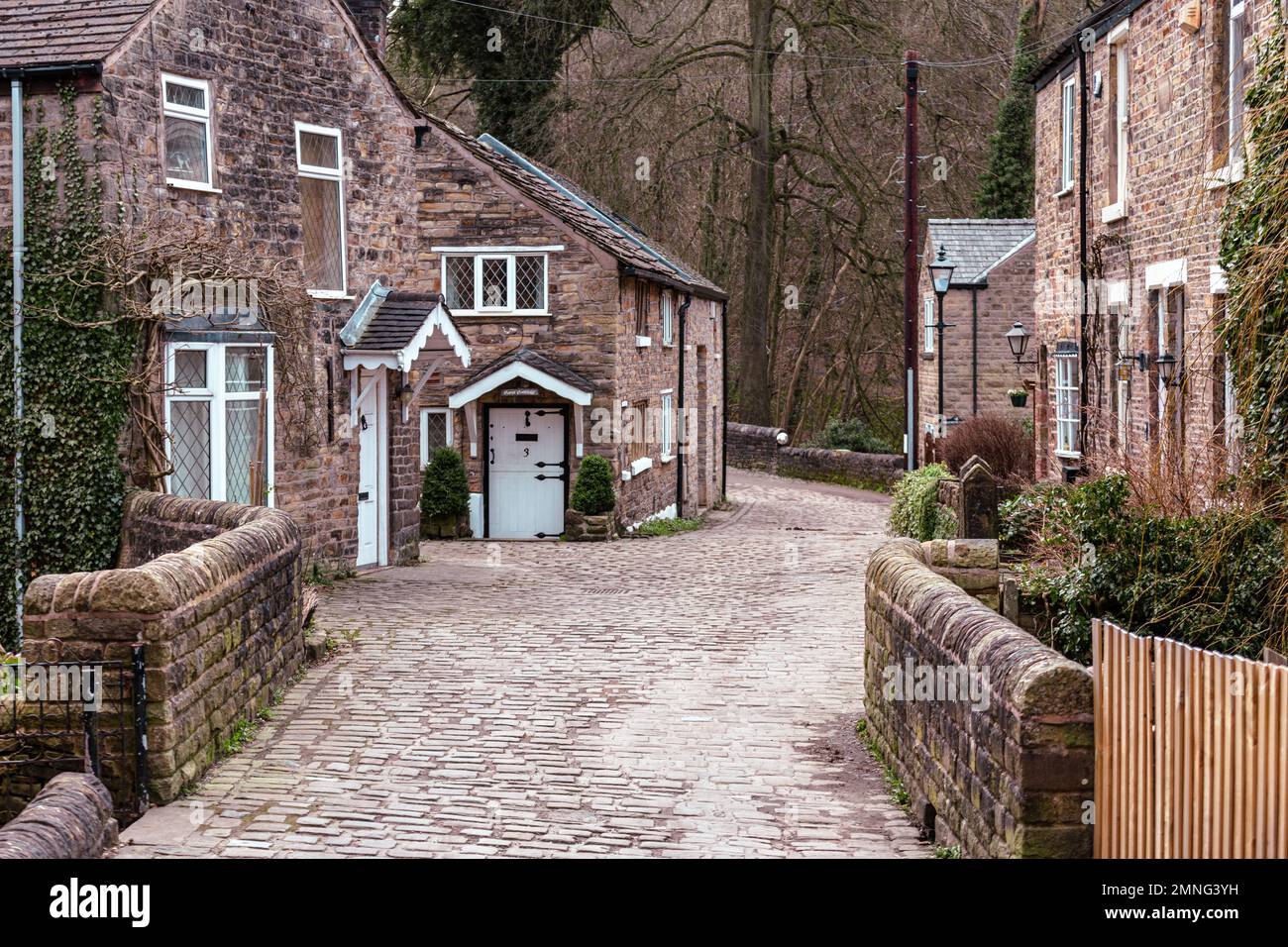Lea Road una strada acciottolata tradizionale che lascia il centro del paese su un vecchio ponte di pietra. Marple Bridge, Greater Manchester, Inghilterra, Regno Unito Foto Stock