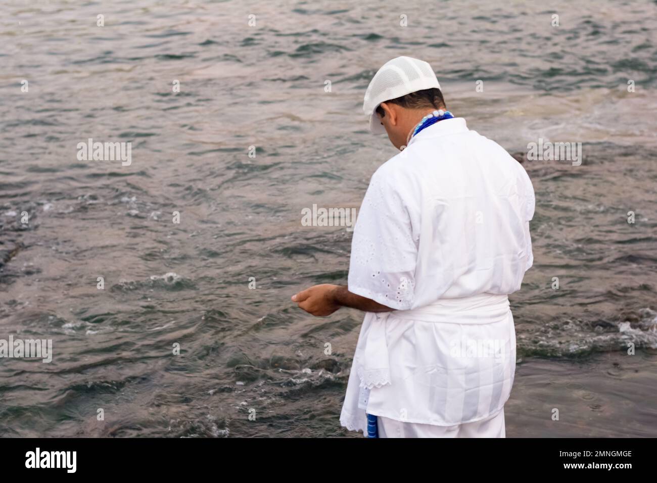 Salvador, Bahia, Brasile - 02 febbraio 2017: Un uomo che ammira Candomble rende omaggio a Iemanja sulla spiaggia di Rio Vermelho, a Salvador, Bahia. Foto Stock