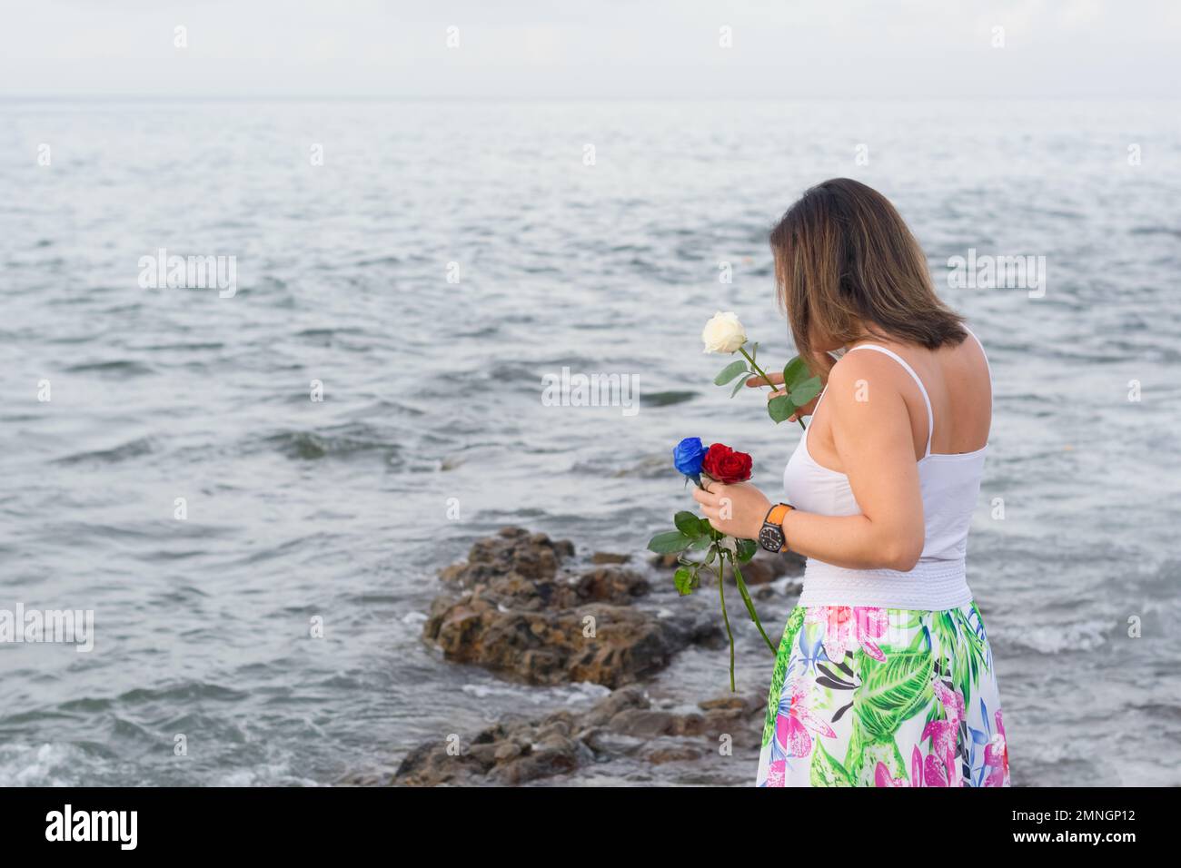 Salvador, Bahia, Brasile - 02 febbraio 2017: Una donna che ammira Candomble getta fiori in mare in onore di Iemanja il giorno della sua festa. Salvador, Foto Stock