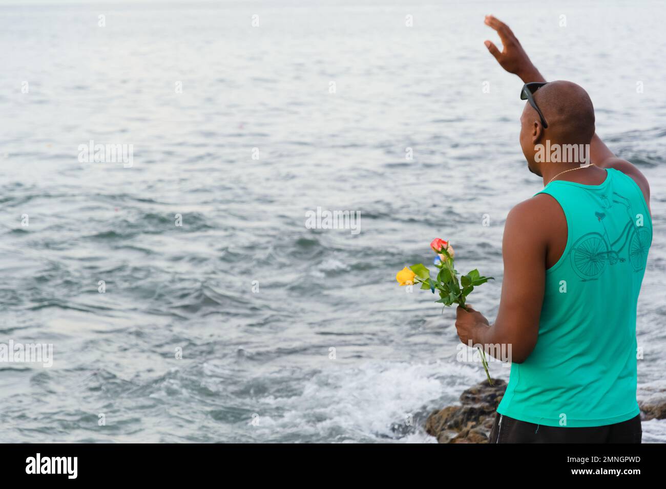 Salvador, Bahia, Brasile - 02 febbraio 2017: Un uomo che ammira Candomble rende omaggio a Iemanja sulla spiaggia di Rio Vermelho, a Salvador, Bahia. Foto Stock