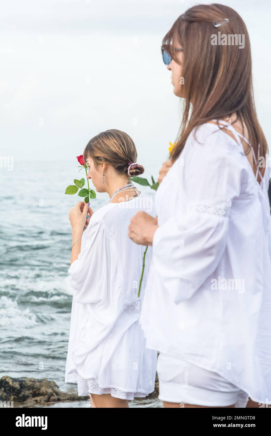 Salvador, Bahia, Brasile - 02 febbraio 2017: Una donna che ammira Candomble getta fiori in mare in onore di Iemanja il giorno della sua festa. Salvador, Foto Stock