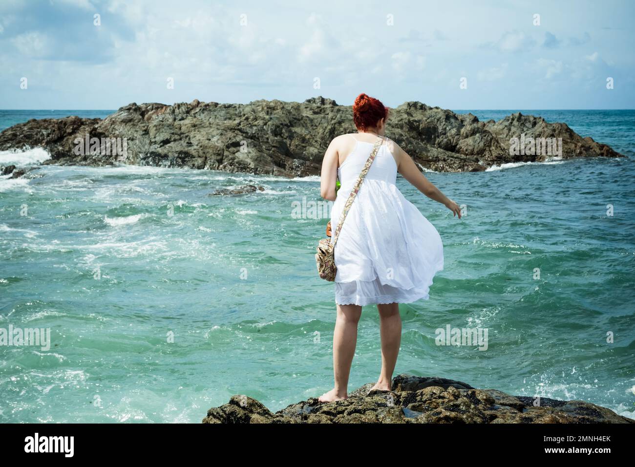 Salvador, Bahia, Brasile - 02 febbraio 2017: Una donna che ammira Candomble getta fiori in mare in onore di Iemanja il giorno della sua festa. Salvador, Foto Stock