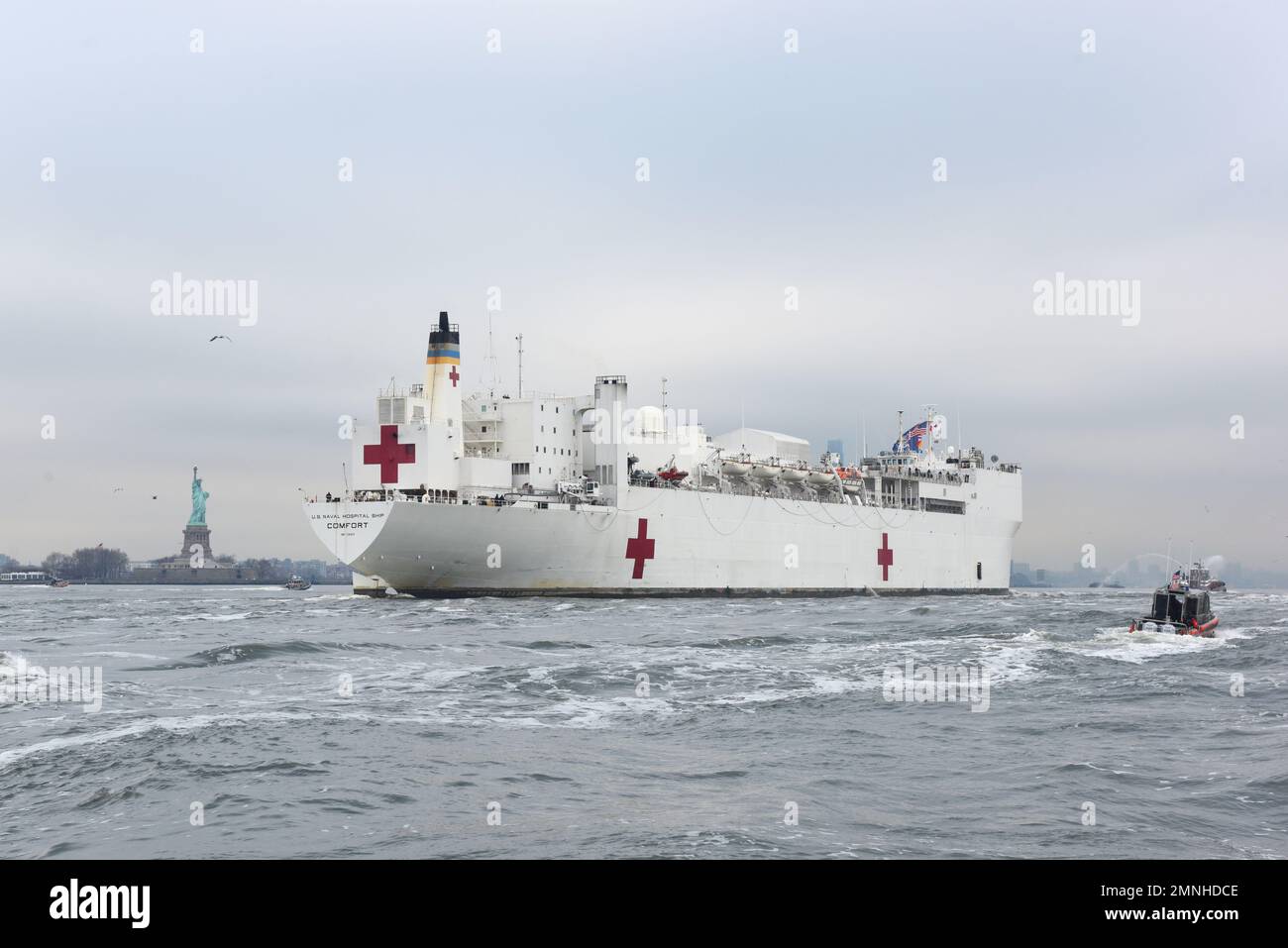 Gli asset della Guardia Costiera, insieme al Dipartimento di polizia di New York e al Dipartimento dei vigili del fuoco di New York, forniscono una scorta di sicurezza per l'arrivo dell'USNS Comfort nel porto di New York, il 30 marzo 2020. La Guardia Costiera Cutter Shrike, la Guardia Costiera Cutter Sitkinak, il Maritime Safety and Security Team di New York, e gli equipaggi della Guardia Costiera della Stazione di New York e della Guardia Costiera della Stazione aerea di Cape Cod hanno condotto la scorta mentre il Comfort è arrivato a New York per assistere nella risposta del COVID-19. Foto Stock