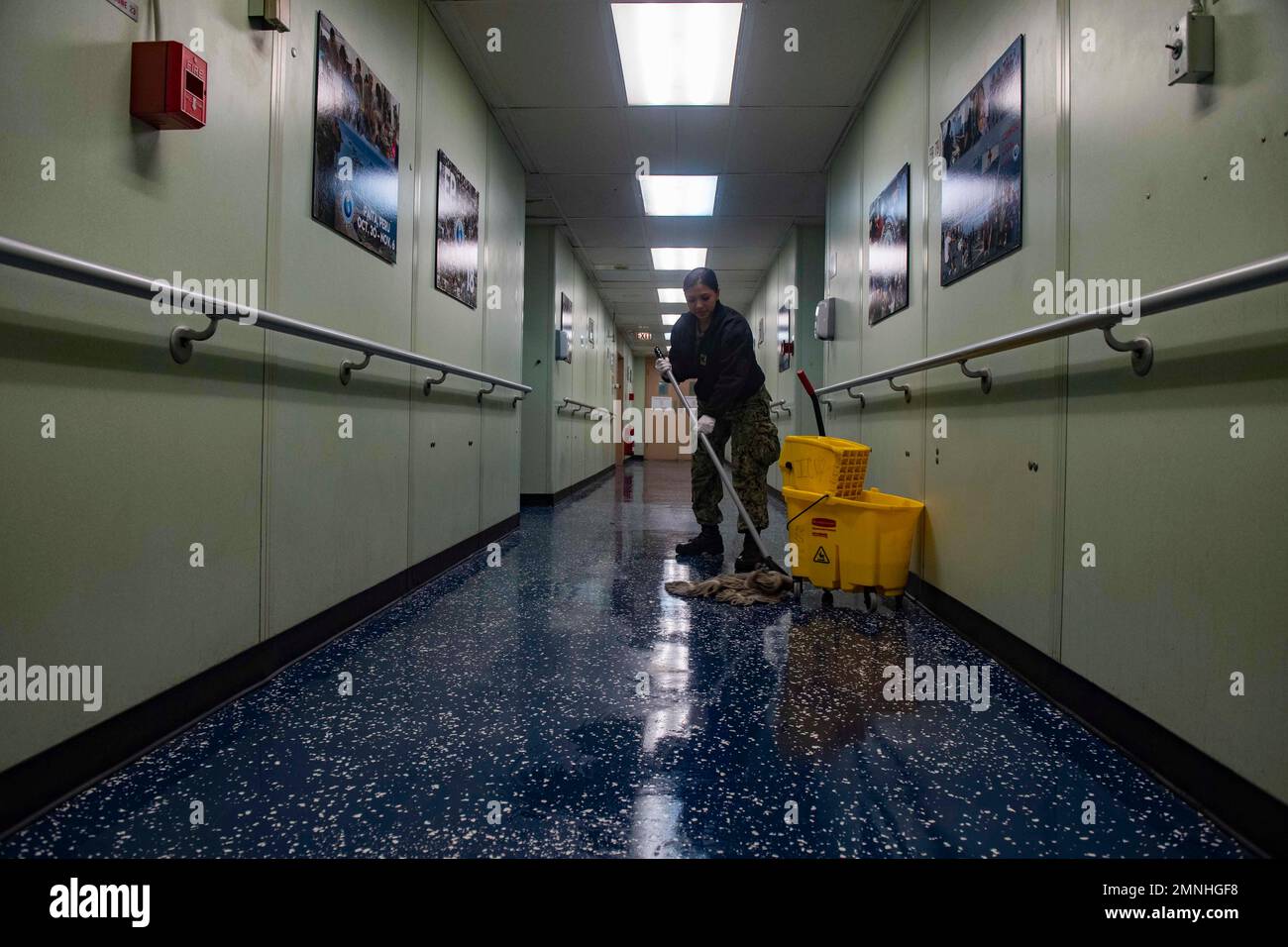 Un ospedale Corpsman 3rd Classe mop un ponte a bordo della nave ospedaliera USNS Comfort (T-AH 20) mentre la nave si prepara ad ammettere i pazienti, a New York City, a sostegno degli sforzi di risposta della nazione COVID-19 ca. 2020 Foto Stock