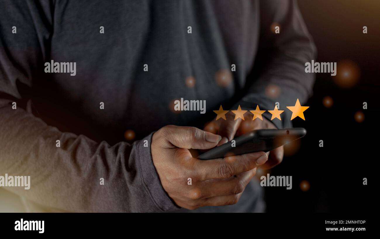 Soddisfazione primo piano sulla mano dell'uomo del cliente premendo sullo schermo con l'icona di feedback di valutazione a cinque stelle e il livello di pressione eccellente classifica per dare il miglior punteggio Foto Stock