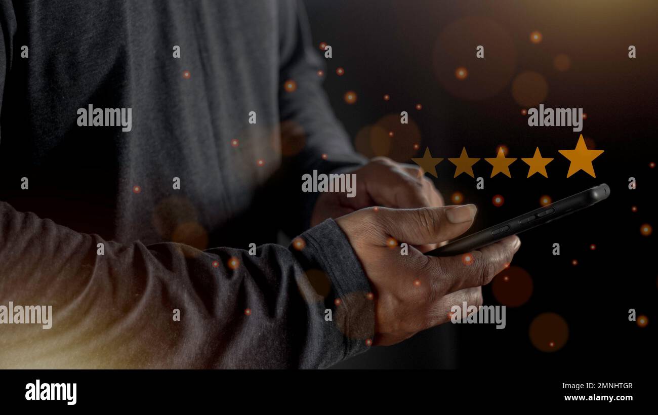 Soddisfazione primo piano sulla mano dell'uomo del cliente premendo sullo schermo con l'icona di feedback di valutazione a cinque stelle e il livello di pressione eccellente classifica per dare il miglior punteggio Foto Stock