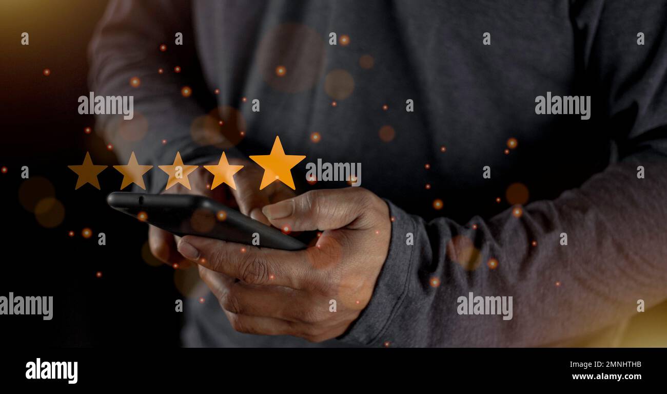 Soddisfazione primo piano sulla mano dell'uomo del cliente premendo sullo schermo con l'icona di feedback di valutazione a cinque stelle e il livello di pressione eccellente classifica per dare il miglior punteggio Foto Stock