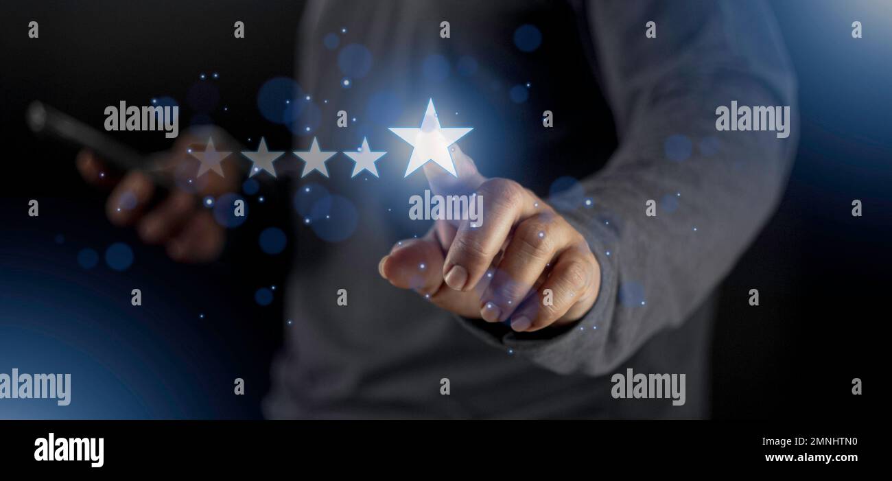 Soddisfazione primo piano sulla mano dell'uomo del cliente premendo sullo schermo con l'icona di feedback di valutazione a cinque stelle e il livello di pressione eccellente classifica per dare il miglior punteggio Foto Stock