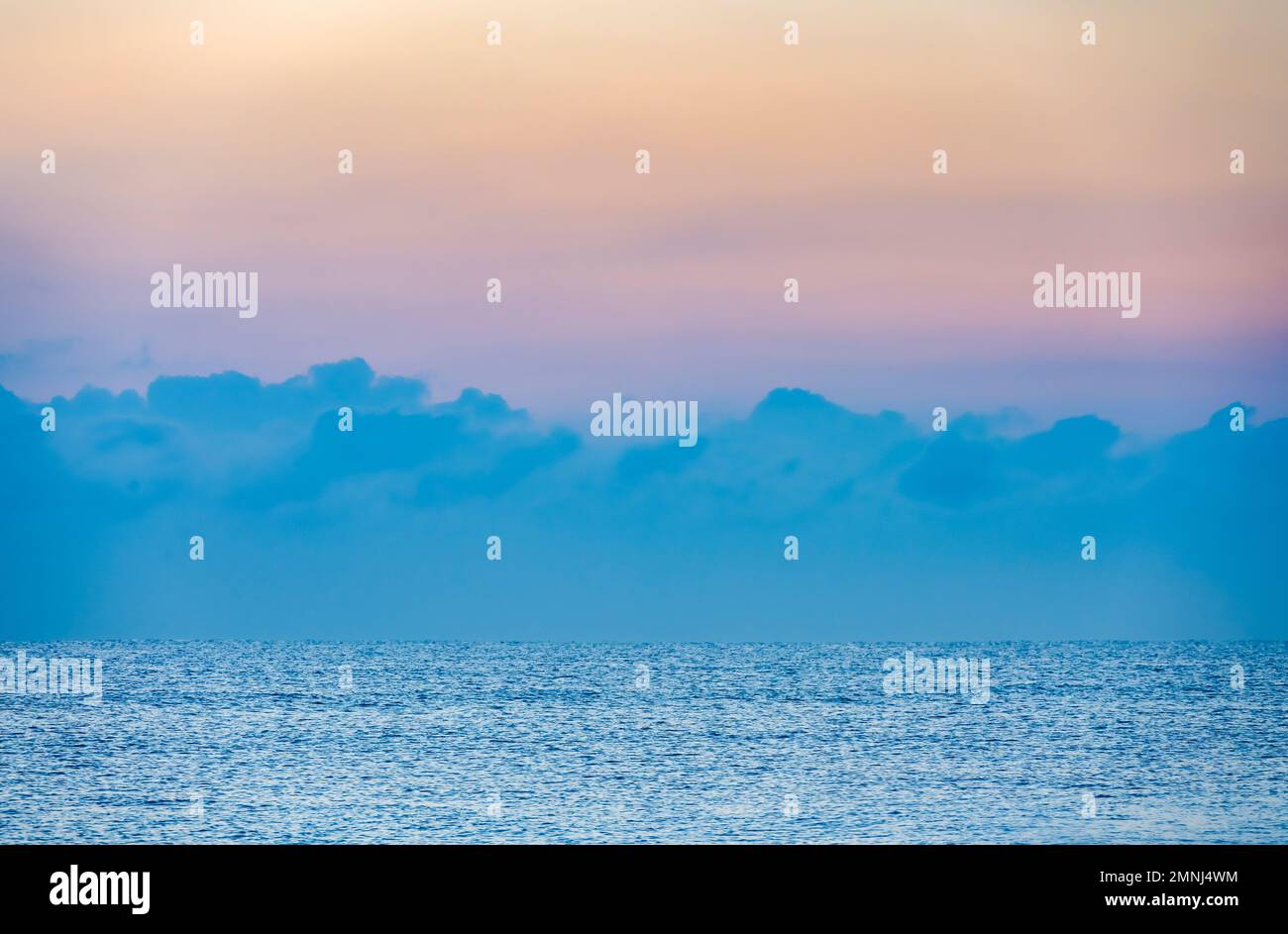 Nuvole sopra l'oceano calmo all'alba Foto Stock