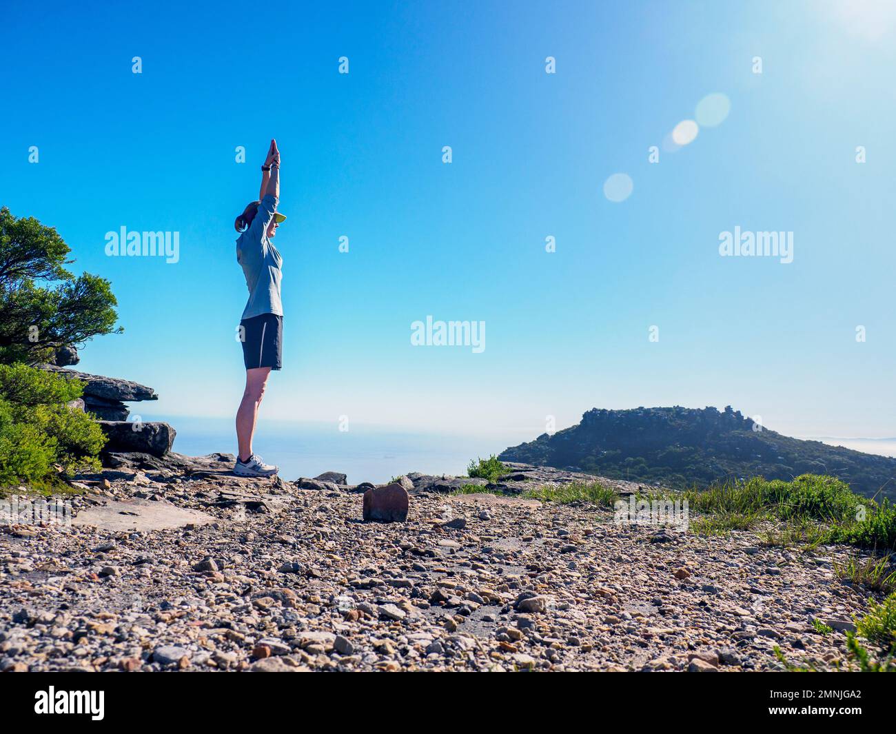 Sud Africa, Capo Occidentale, Città del Capo, Donna in piedi sulla scogliera con le armi sollevate Foto Stock