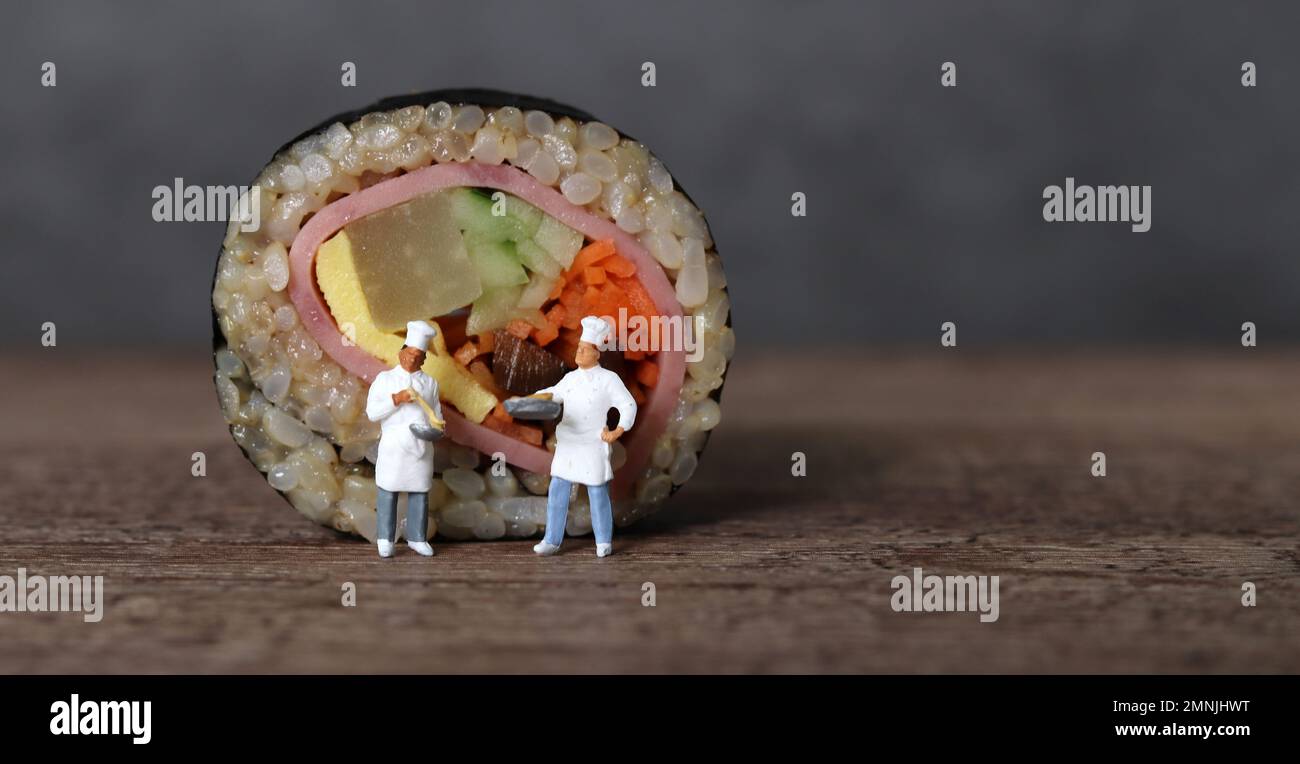 Gimbap di verdure al prosciutto fatto con riso marrone. Persone in miniatura e Gimbap con concetto di business. Foto Stock