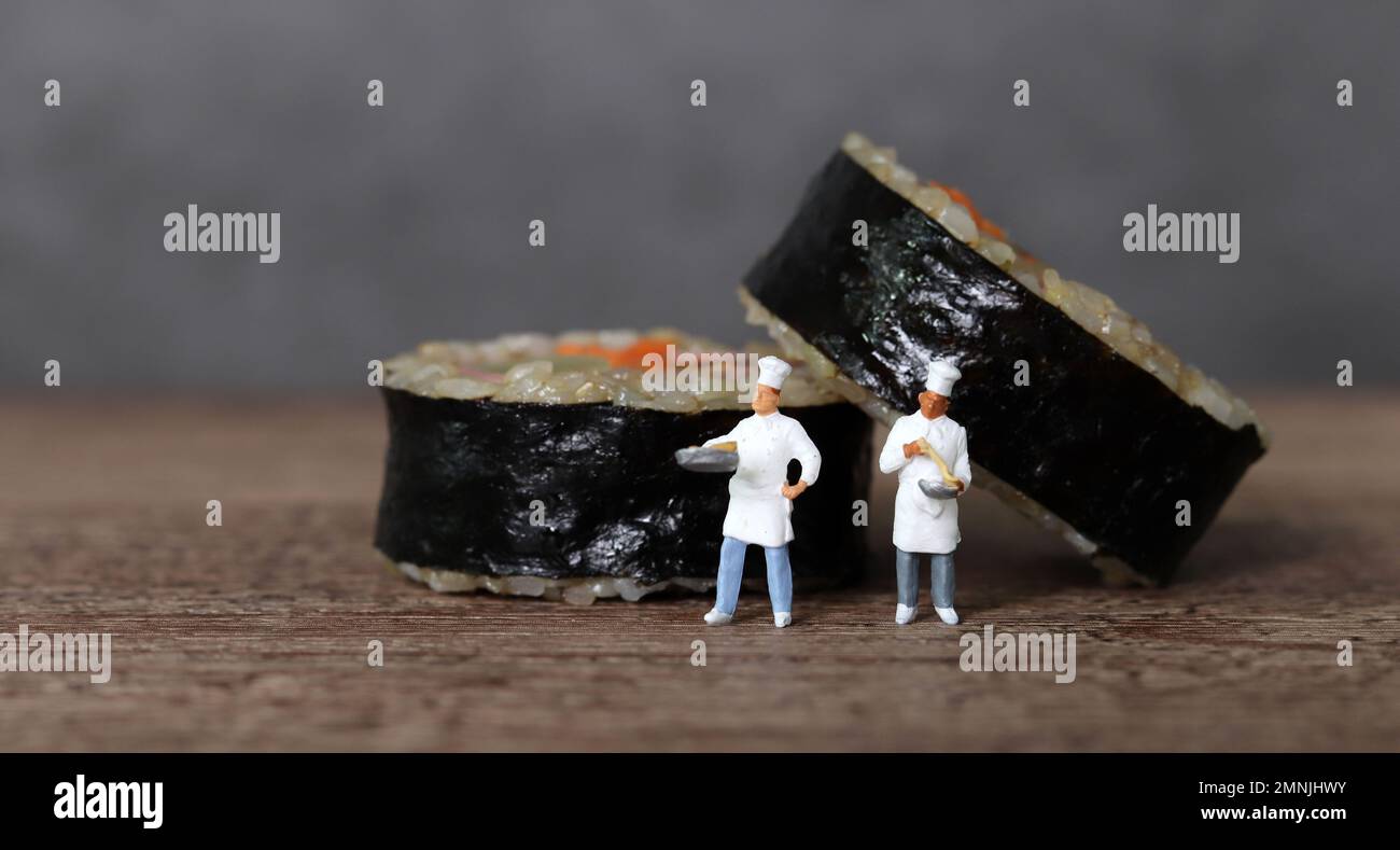 Gimbap di verdure al prosciutto fatto con riso marrone. Persone in miniatura e Gimbap con concetto di business. Foto Stock