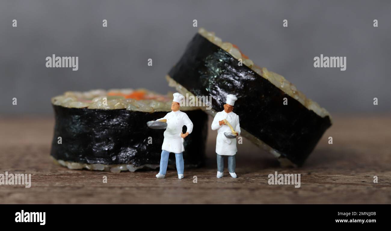 Gimbap di verdure al prosciutto fatto con riso marrone e due cuochi in miniatura. Persone in miniatura e Gimbap con concetto di business. Foto Stock