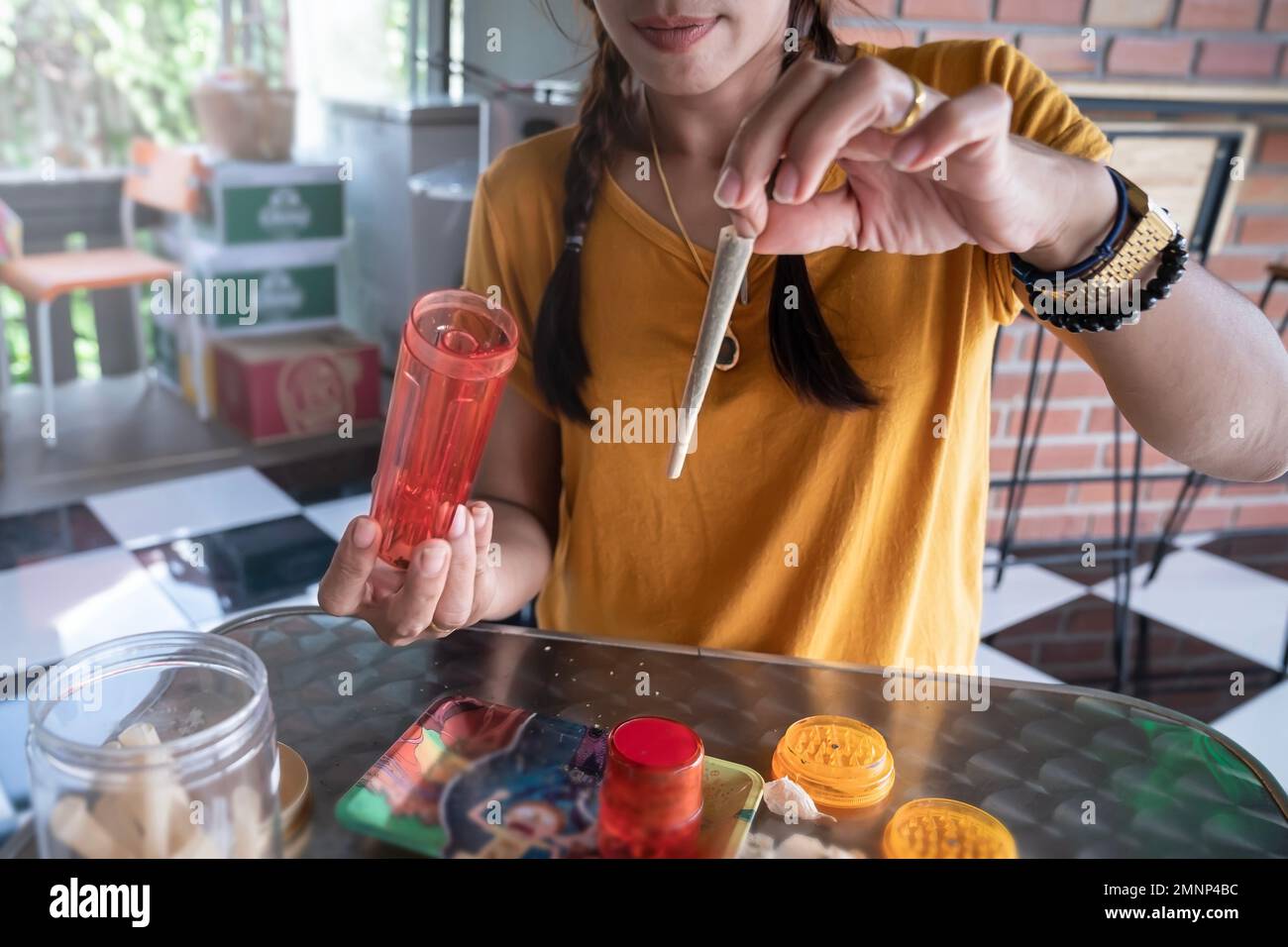 Una donna dimostra una congiunzione di una sigaretta con la marijuana. Legalizzazione della cannabis in Thailandia Foto Stock