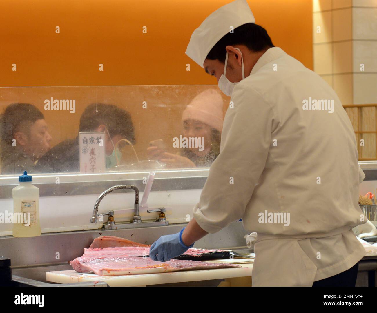 Lo chef del sushi serve un pesce di tonno fresco al ristorante Kaiten Sushi di Tokyo, Giappone. Foto Stock