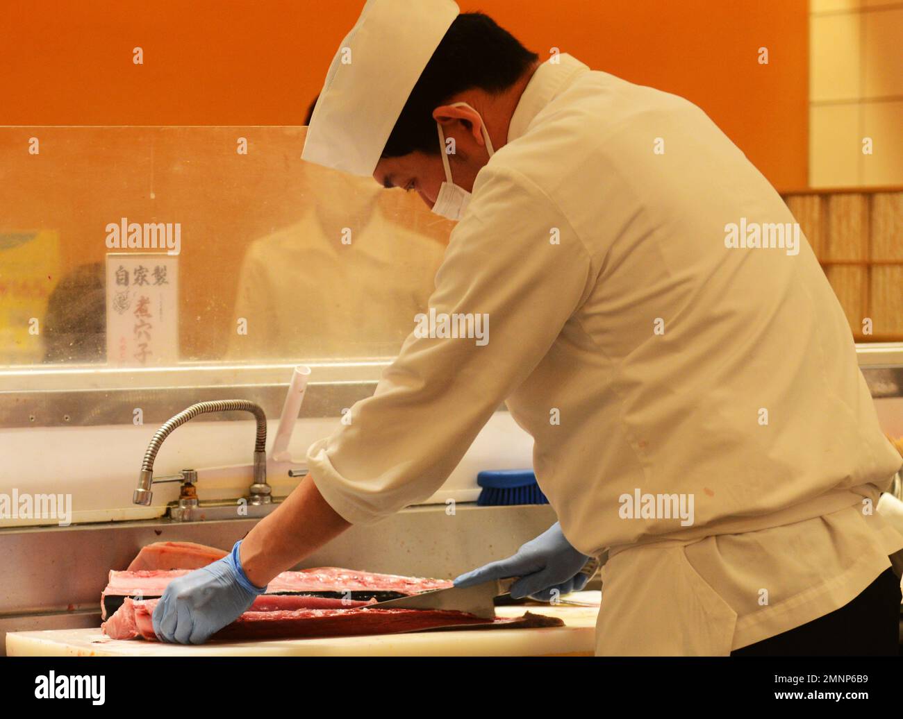 Lo chef del sushi serve un pesce di tonno fresco al ristorante Kaiten Sushi di Tokyo, Giappone. Foto Stock