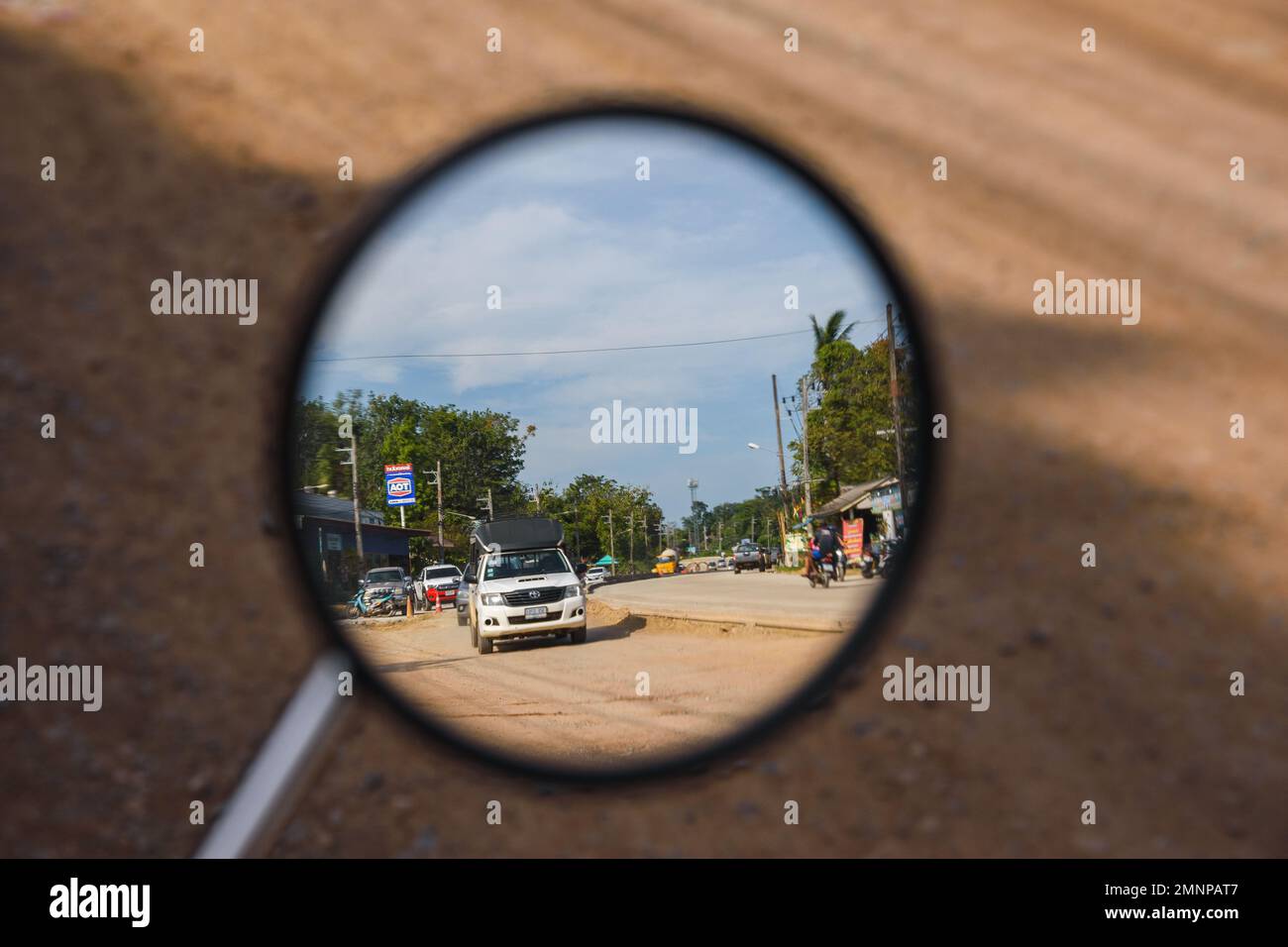 Traffico di una strada di campagna della Thailandia su uno specchio retrovisore di una moto. Ko Lanta, Krabi, Thailandia. Dicembre 1, 2022. Foto Stock