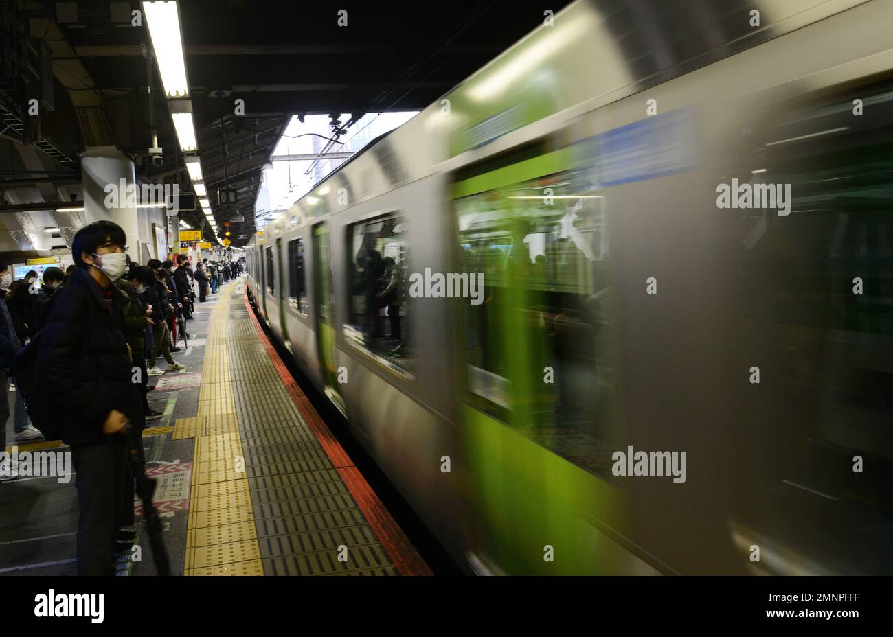 Passeggeri giapponesi in attesa della linea JR Yamanote a Tokyo, Giappone. Foto Stock