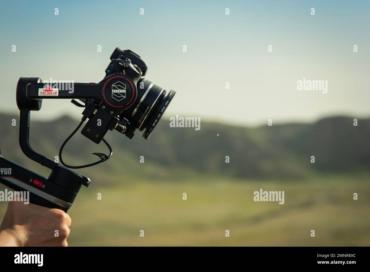Stabilizzatore compatto a tre assi Zhiyun Weebill S in mano operatore all'aperto Foto Stock