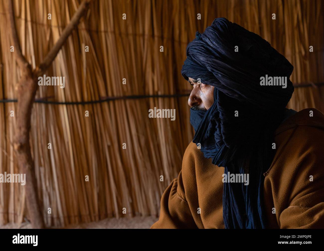 Tuareg nella sua casa di canna guardando lontano, Nord Africa, Tamanrasset, Algeria Foto Stock