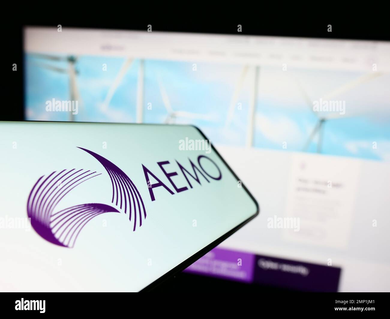 Smartphone con logo dell'operatore australiano del mercato dell'energia (AEMO) sullo schermo davanti al sito Web. Messa a fuoco al centro a sinistra del display del telefono. Foto Stock