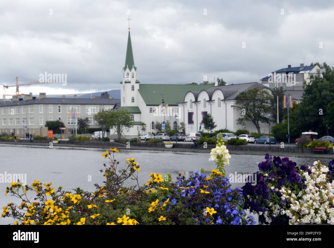 Islanda, Reykjavik: Vista della Frikirkjan (libera Chiesa luterana), sul lato del lago Tjörnin, con le vicine isole Listasafn (Galle Nazionale Foto Stock