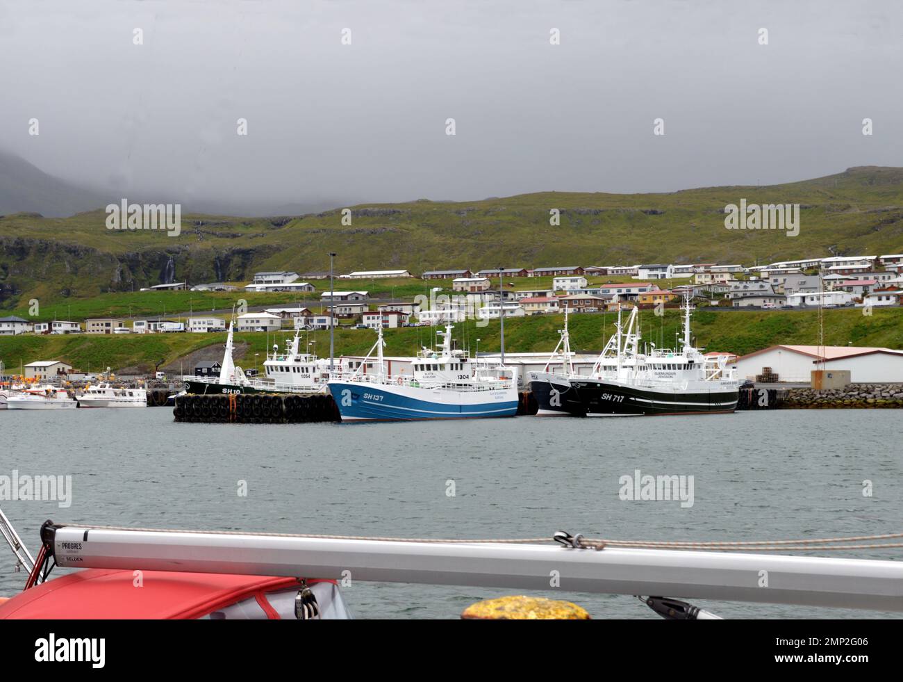 Islanda, Ólafsvík: La più antica città commerciale dell'Islanda, con il suo statuto risalente al 1687. Barche da pesca nel porto, dominato dalla sett Foto Stock