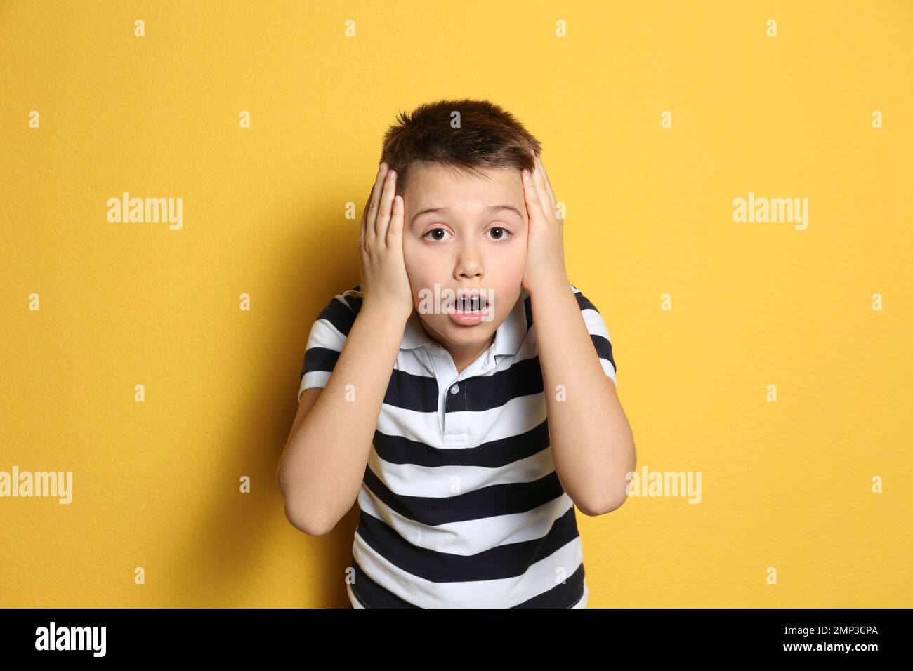Ritratto del ragazzo premiante emozionale su sfondo giallo Foto Stock