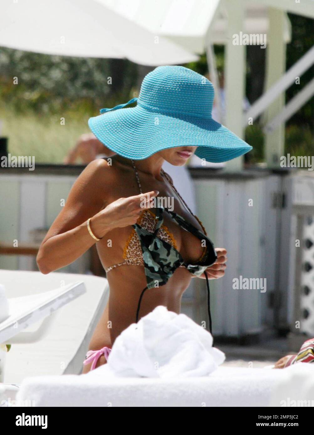 Esclusivo!! Sempre l'esibizionista Shauna Sand cambia bikini in vista piana su Miami Beach. L'ex mago Playmate comprò un nuovo bikini da un venditore di spiaggia e mise il nuovo camouflage uno sopra il suo vecchio rosa. Poi il suo amico maschio hunky l'ha aiutata a rimuovere il vecchio prima di andare per un romp nel surf, Miami Beach, FL, 4/24/08. Foto Stock